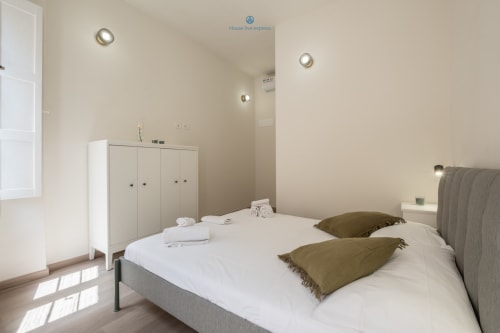Camera moderna al House Live Express di Cagliari con letto matrimoniale, cuscini verde oliva, armadio bianco e illuminazione incassata