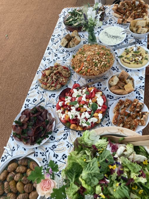 Mediterranean spread at Agriturismo Colle Mura featuring fresh salads, mezze, grilled meats, and edible flowers in Gualdo