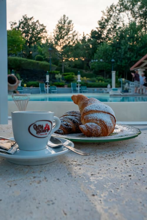 Coffee and pastries overlooking pool at Country House Bosco d'Olmi, Italian countryside B&B
