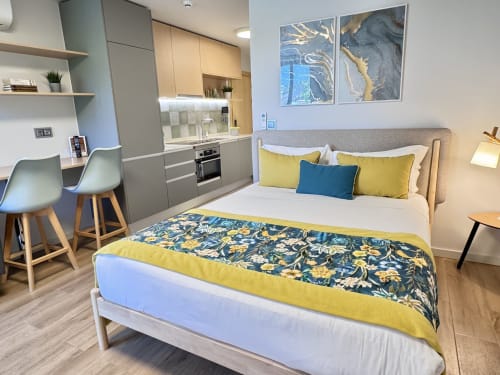 Apartamento Premium Green no RIA CENTRUM em Aveiro com cama, detalhes amarelos, kitchenete e área de trabalho
