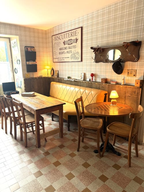 Salle à manger de style rétro au Comme chez Louise B&B à Plestin les Grèves avec tables en bois, banquettes jaunes et ambiance vintage