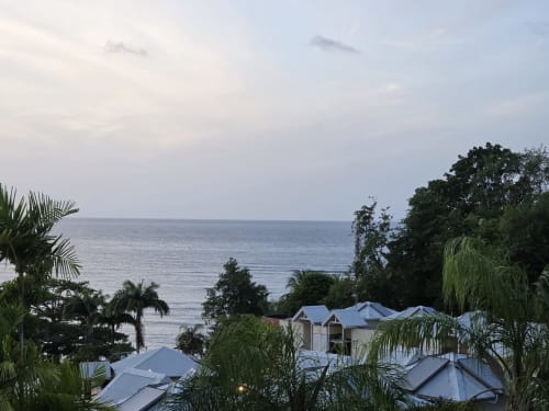 Vue depuis le balcon de la Suite Azur à Clémara Evasion en Martinique avec océan, palmiers et bâtiments de la station