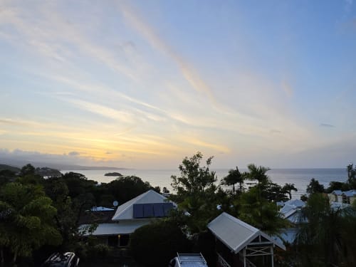 Coucher de soleil sur la mer des Caraïbes depuis la Suite Azur de Clémara Evasion, Schœlcher, Martinique, avec jardins tropicaux et architecture moderne
