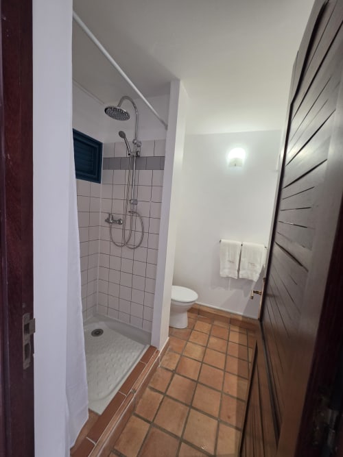 Salle de bain moderne de la Suite Azur au gîte Clémara Evasion à Schœlcher, douche italienne, toilettes et carrelage terre cuite