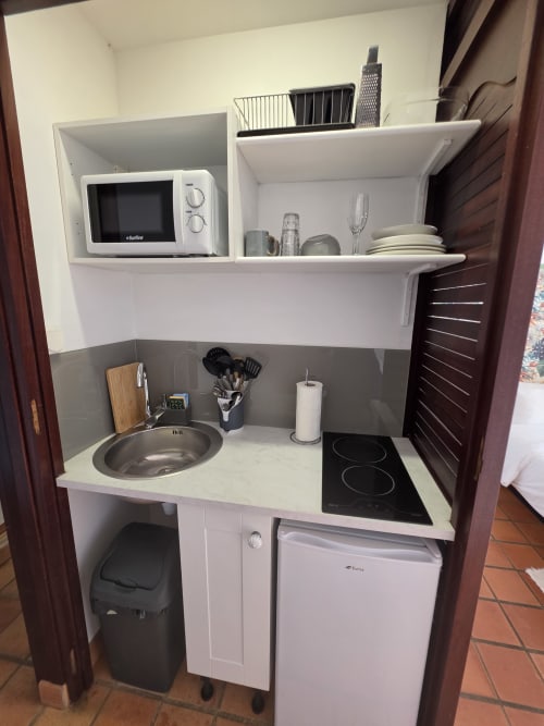 Kitchenette compacte de la Suite Azur à Clémara Evasion, Schœlcher, équipée d'un micro-ondes, plaque de cuisson, évier et réfrigérateur
