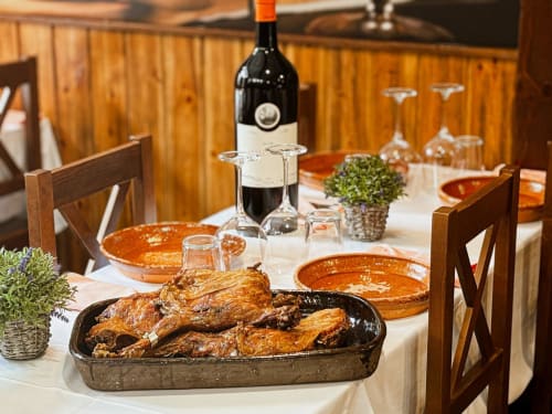 Mesa de comedor elegante en Palacio Mambrilla, Valladolid, con pato asado, vino y vajilla