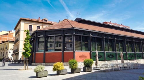 Entrada del hotel Palacio Mambrilla en Valladolid con fachada moderna de vidrio y terraza con asientos