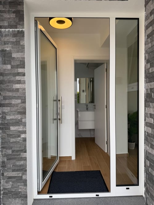 Entrada moderna da casa de banho na villa Check Madeira em Ribeira Brava com lavatório, espelho, pavimento em madeira e design contemporâneo