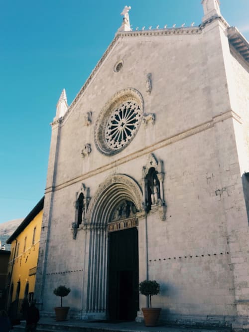 Storica facciata di chiesa in pietra bianca a Norcia, Italia vicino a Le Mura Rooms and Apartments