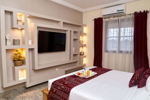 Chambre supérieure de l'Hôtel Yakro à Yamoussoukro avec TV écran plat, mobilier moderne et vue sur la ville