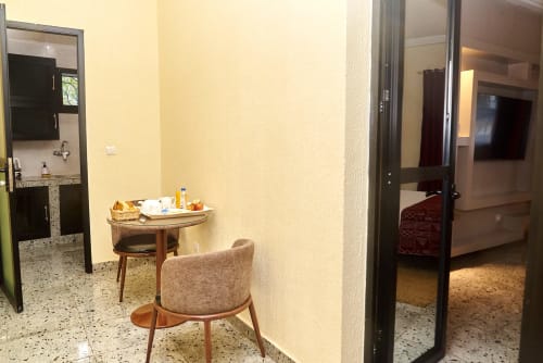 Chambre supérieure Hôtel Yakro à Yamoussoukro avec mobilier moderne, kitchenette et vue sur la ville