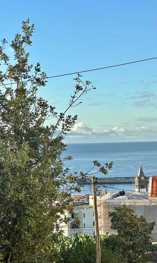 Vista da costa a partir das Villas Simone mostrando o mar Mediterrâneo, porto, torre da igreja e arquitetura local