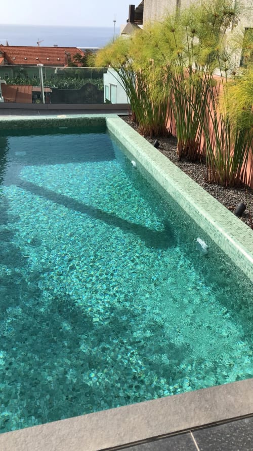 Piscina cristalina turquesa nas Villas Simone com gramas ornamentais, terraço e vista para o mar em Portugal