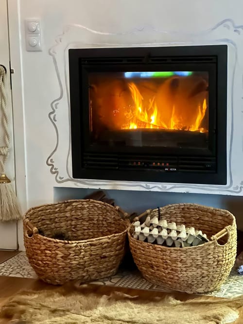 Aconchegante lareira com cestos trançados na Villas Simone, aluguel de férias em Portugal