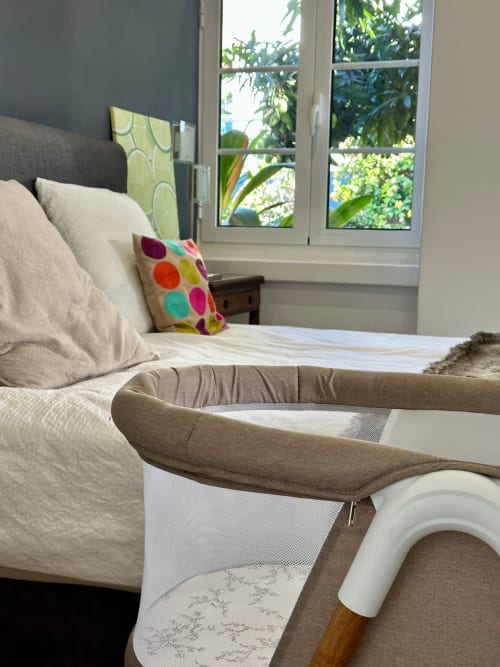 Quarto luminoso na Villas Simone com cama, almofadas coloridas e vista para o jardim pelas portas-janelas, Portugal