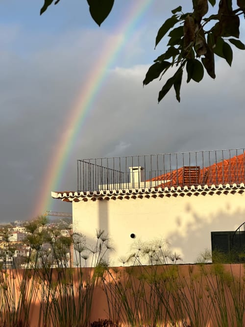 Arco-íris sobre a varanda da cobertura de Villas Simone com gramíneas ornamentais e vistas para o litoral, Portugal