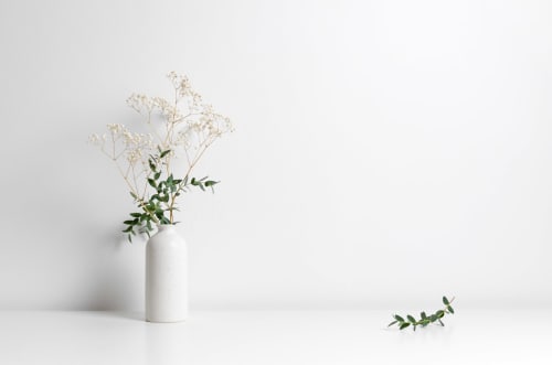 Vaso minimalista branco com arranjo de mosquitinho e verduras no hotel de luxo Villas Simone