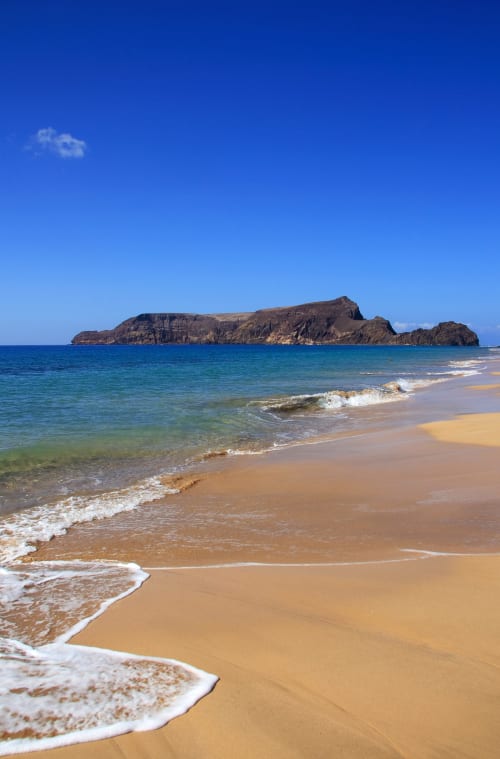 Praia de areia com ondas turquesas e ilha rochosa ao largo, Villas Simone Portugal