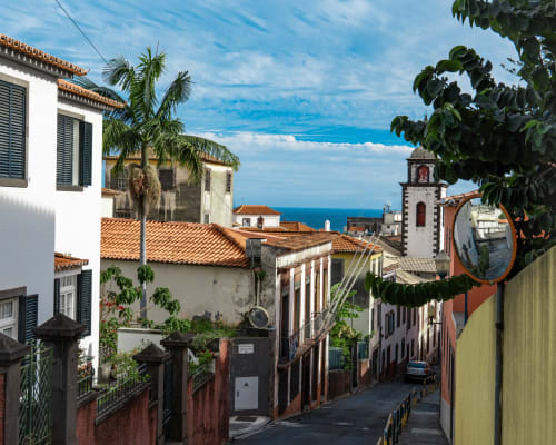 Villas Simone: encantadora rua com edifícios coloniais brancos, telhados de terracota e horizonte do oceano em Portugal