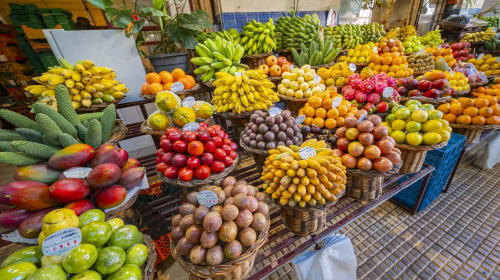 Colorida exposição de mercado de frutas tropicais em Villas Simone Portugal com bananas, mangas, cítricos e produtos locais
