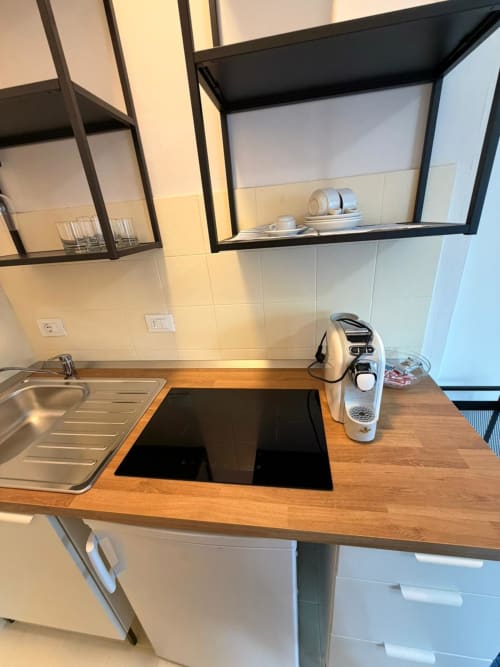 Cucina moderna nell'appartamento 205 Porta Romana Suite Milano, con piano di lavoro in legno, piano cottura a induzione e acciaio inossidabile