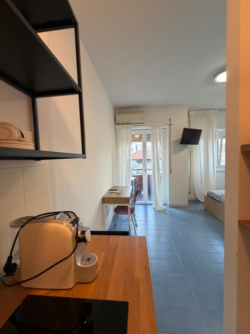 Luminoso monolocale a Porta Romana Suite Milano con angolo cottura, arredamento moderno e accesso al balcone