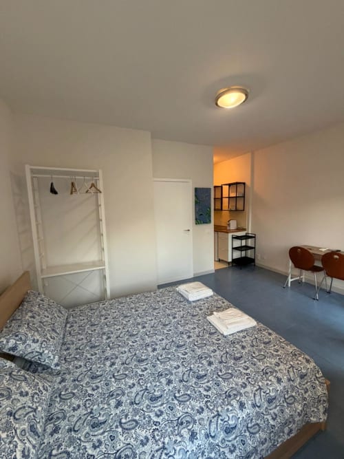 Luminoso monolocale a Porta Romana Suite Milano con letto, angolo cottura, zona living e moderna plafoniera