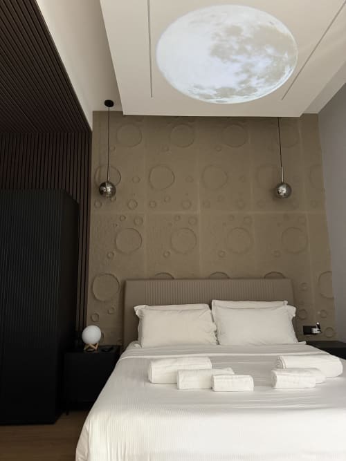 Camera Moon della Modern Suite presso Eterna Suites Roma, con biancheria bianca, testata circolare decorata, luci a sospensione e