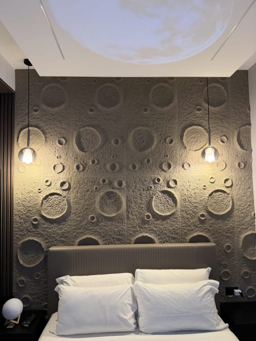 Camera Suite Moon di Eterna Suites Roma con decorazioni murali a tema lunare, illuminazione a sospensione e cuscini bianchi