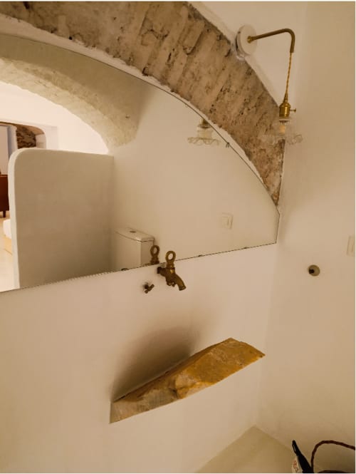 Banheiro rústico com viga de pedra aparente e metais vintage em latão no apartamento Casas Velhinhas, Estremoz