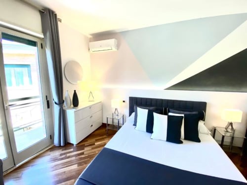 Camera da letto superior presso Mottola Apartments a Tropea con vista sul giardino, arredamento moderno e accesso al balcone