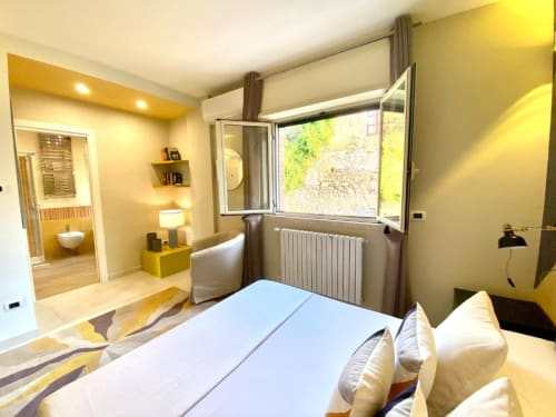 Camera da letto moderna con vista giardino, letto queen e bagno ensuite presso Mottola Apartments a Tropea