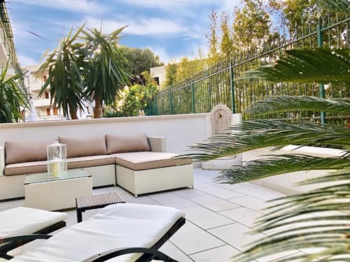 Terrazza degli Appartamenti Mottola a Tropea con comodi sedili, lettini, piante tropicali e vista sul giardino