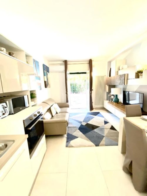 Moderno appartamento di lusso con cucina e zona living rifinite in beige, tappeto geometrico e vista sul giardino - Mottola Apartments, Tropea