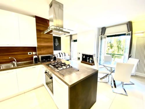 Cucina moderna e zona living nell'Appartamento Superior di Mottola Apartments, Tropea con piano cottura a isola, mobili bianchi e