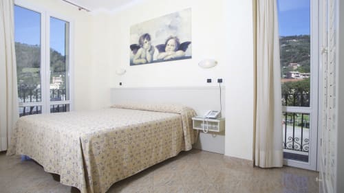 Suite luminosa all'Hotel Feluca a Bonassola con balcone vista mare, letto queen size e pavimenti in cotto