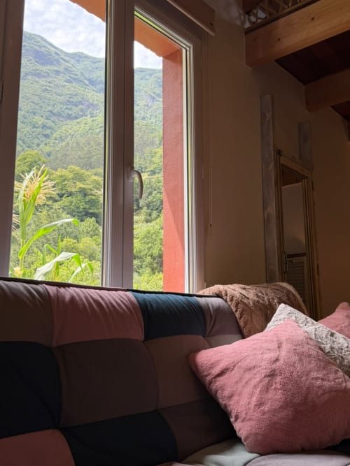 Quarto aconchegante no Refúgio do Nevoeiro com vistas de montanha pela porta aberta em São Vicente