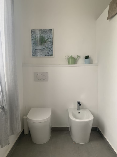 Bagno moderno a Ca' Salino con sanitari bianchi, bidet, piante in vaso e arredi minimalisti a Villa Inferno