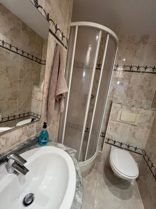 Baño moderno en el apartamento Olivos del Sol, Sant Jordi, con ducha, lavamanos blanco, inodoro y paredes alicatadas