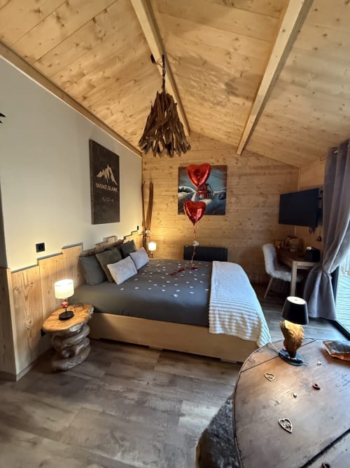 Chambre romantique du lodge Coeur de lodge avec ballons cœurs, affiche vue montagne, télévision écran plat et décoration rustique