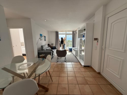 Área de estar moderna de apartamento con mesa de comedor, sofá y balcón con vistas al jardín del campo de golf en Home Guardian Services,