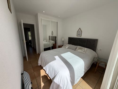 Dormitorio moderno del apartamento Sant Jordi con cama queen, armario espejo y suelo de terracota