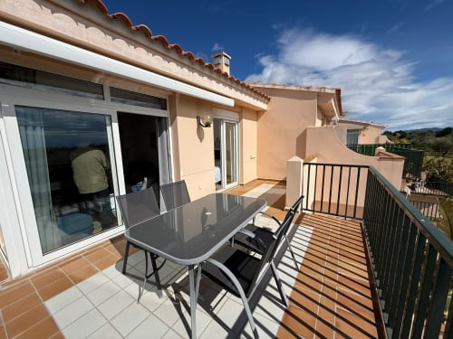 Terraza con mesa de comedor en apartamento con vistas al golf en Sant Jordi, puertas correderas y balcón amueblado