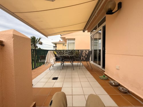 Amplia terraza del apartamento Sant Jordi con toldo retráctil, comedor y vistas al campo de golf
