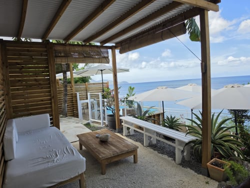 Beachfront terrace at Clémara Evasion in Martinique with lounge seating, ocean views, and tropical plants