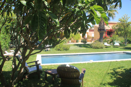 Jardin du Clos BB avec chaises longues au bord de la piscine sous les arbres, villa en terre cuite à Saint-Cyr sur Mer
