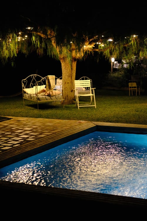 Jardin illuminé du Clos Bb B&B avec piscine, espace détente et saule pleureur la nuit
