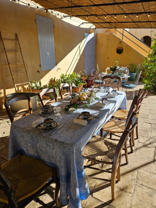 Élégante terrasse de Clos Bb à Saint-Cyr sur Mer avec table conviviale, chaises rustiques et ambiance méditerranéenne