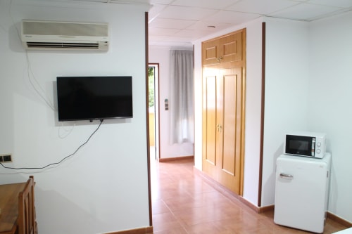 Habitación triple en Mesón Hotel El 21 de Níjar con TV, refrigerador, aire acondicionado y armario de madera