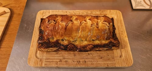 Golden-brown meat pie on wooden board at Aux Prés Du Berry, French countryside B&B in Chavin